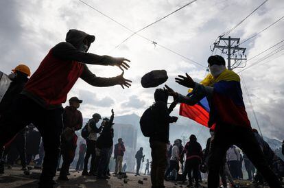 Un manifestante pasa una piedra a otro para construir una barricada durante las protestas de este jueves, en Quito.