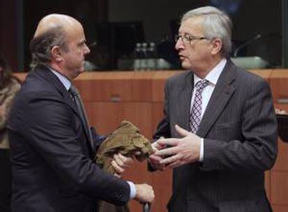 El ministro de Economía de España, Luis de Guindos (izda), conversa con el presidente del Eurogrupo, Jean-Claude Juncker, antes de la reunión de los ministros de Economía y Finanzas de la Unión Europea (Ecofin), en la sede de Bruselas, Bélgica. EFE/Archivo