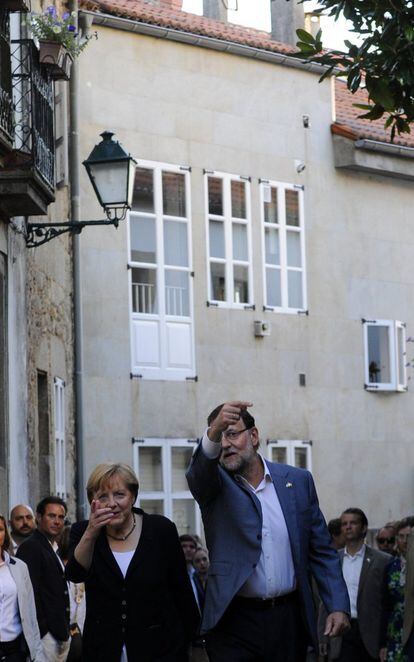 Mariano Rajoy hace indicaciones a Ángela Merkel en el paseo que ambos realizaron este domingo por las calles del centro de Santiago.