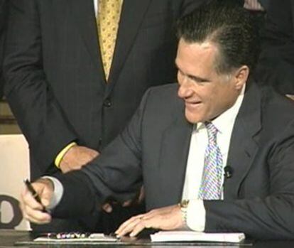 Mitt Romney, al firmar la ley de reforma sanitaria.