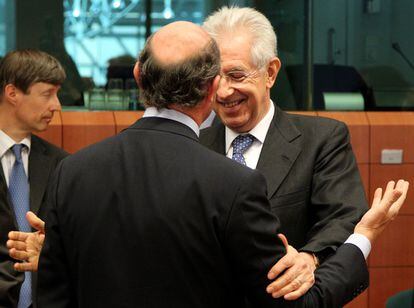 El Primer Ministro italiano, Mario Monti, saluda a Luis de Guindos (de espaldas) a su llegada a la reunión del Eurogrupo