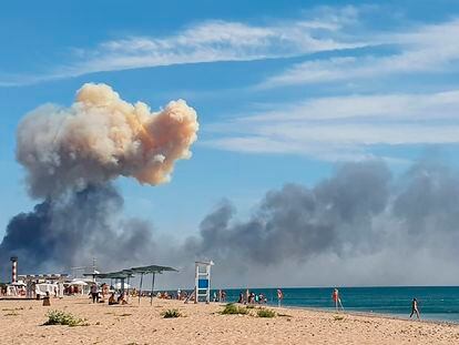 FILE - Rising smoke can be seen from the beach at Saky after explosions were heard from the direction of a Russian military airbase near Novofedorivka, Crimea, Aug. 9, 2022. (UGC via AP, File)