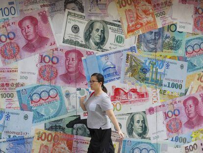 Una mujer pasa junto a una oficina de cambio en Hong Kong.