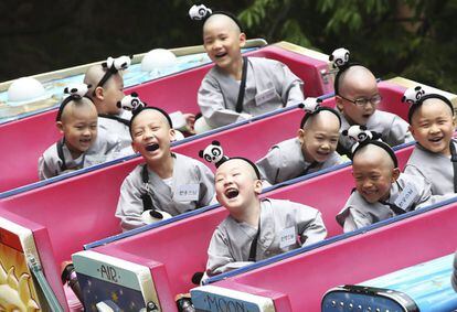 Jóvenes monjes budistas disfrutan de una atracción en un parque de atracciones en Seúl, Corea del Sur.