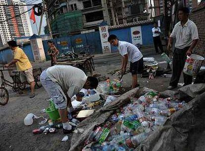 Ciudadanos chinos recogen basura en una calle de Pekín.