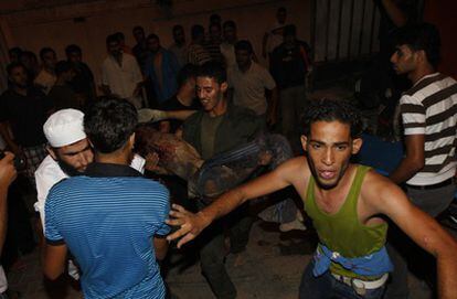 Los palestinos llevan a los heridos al tras un bombardeo israelí en la ciudad Rafha, al sur de la franja de Gaza.