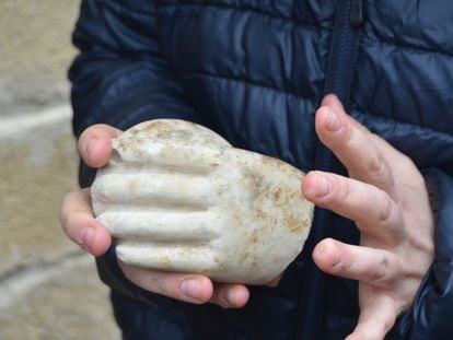 Un arqueólogo muestra la mano de mármol hallada en Artieda.