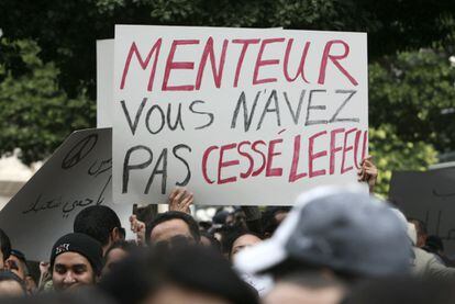 Un ciudadano sostiene una pancarta en la que pone: "Menteur, vous n'avez pas cessé lefeu" ("Mentiroso, usted no paró el fuego").