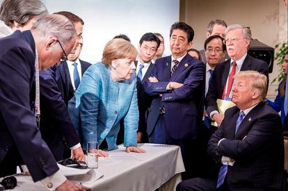 Trump escucha a Merkel y  Macron ante Shinzo Abe (de pie, en el centro), en 2018 en la cumbre del G7 en Charlevoix (Canadá).