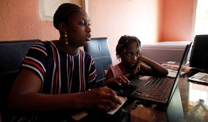 Kesieana Onoge y su hija Naomi, de seis años, siguen un programa de aprendizaje en internet diseñado por la escuela de la niña durante el confinamiento impuesto por el Gobierno para contener la pandemia de covid-19. En Lagos, Nigeria, 23 de abril de 2020.