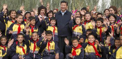 El presidente Xi Jinping posa con unos estudiantes durante su visita a la regi&oacute;n de Xinjiang.