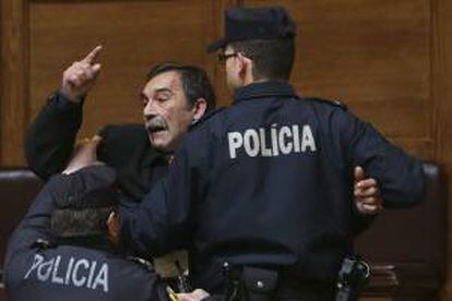 Miembros de la policía arrestan a un hombre que protesta contra el Gobierno durante el discurso del primer ministro luso, Pedro Passos Coelho (no aparece en la imagen), en el debate quincenal parlamentario, en el que se tratan asuntos políticos, económicos y sociales, en Lisboa, Portugal, hoy, miércoles 5 de marzo de 2014.