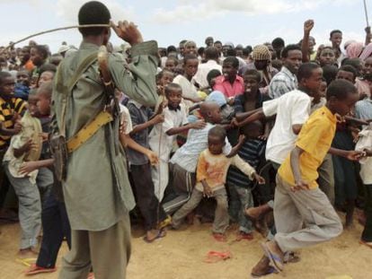 Un miembro de Al Shabaab trata de controlar a manifestantes contra la incursión keniana a las afueras de Mogadiscio.