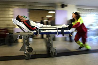 Una sanitaria empuja la camilla de un enfermo en el hospital de Getafe (Madrid), centro de referencia par quemados cr&iacute;ticos. / Gorka Lejarcegi