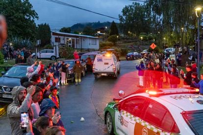 Ciudadanos observan mientras el servicio médico legal traslada el cuerpo del expresidente a la ciudad de Valdivia, este martes en el lago Ranco.