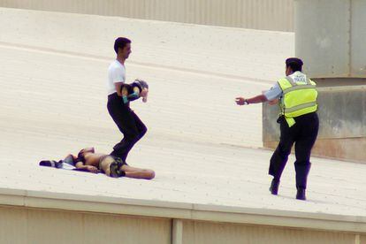 Un miembro de los equipos de rescate saca a un menor del interior del centro comercial.