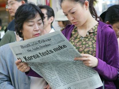 Dos mujeres leen una edición especial sobre la prueba nuclear, en Tokio.