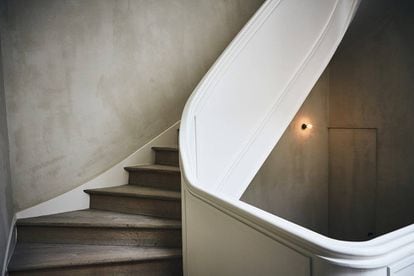 La escalera en blanco conecta las tres plantas del edificio.