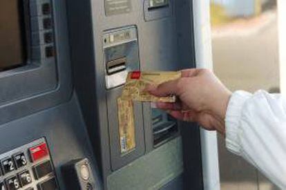 Una mujer saca dinero de un cajero automático. EFE/Archivo