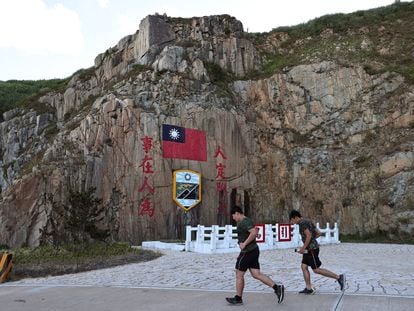 Soldiers march past a sign of the Taiwan flag on Dongyin island of Matsu archipelago in Taiwan August 15, 2022. REUTERS/Ann Wang