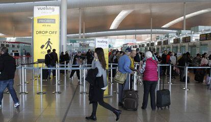 Decenas de pasajeros ante los puestos de facturaci&oacute;n de Vueling en el aeropuerto de Barcelona-El Prat.