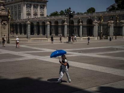 Una mujer se protegía del sol el lunes con un paraguas, frente al Palacio Real, en Madrid.