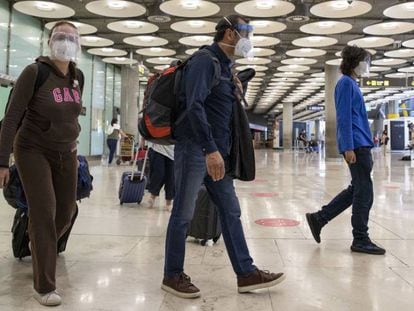 Pasajeros en los pasillos del aeropuerto de Madrid, en junio. 