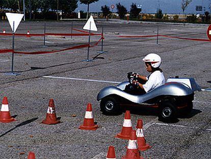 Un niño conduce un <i>kart</i> en un circuito durante el desarrollo de un curso de seguridad vial infantil organizado por la casa de automóviles Audi.