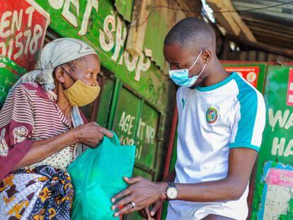 Una residente de Mathare recibe una bolsa con alimentos de Billian.