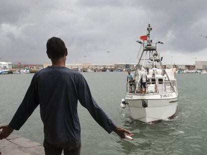 Un vecino de Barbate recibe en el puerto a uno de los pesqueros que regresaron este jueves de Marruecos.