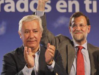 Mariano Rajoy (derecha) y Javier Arenas saludan al público en el mitin de Sevilla.