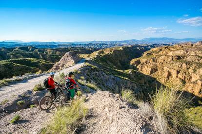 Dos ciclistas observan el desierto de Gorafe, en el geoparque de Granada.