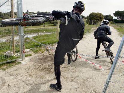 Ciclistas pasando la cadena de uno de los caminos cerrados.