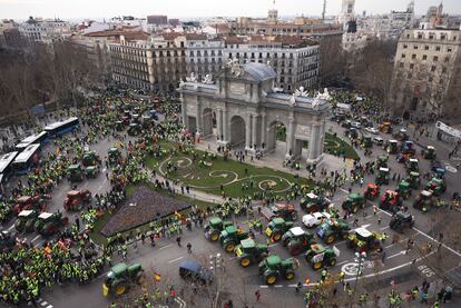 Una fila de tractores a su paso por la Puerta de Alcalá de Madrid, este miércoles. 
