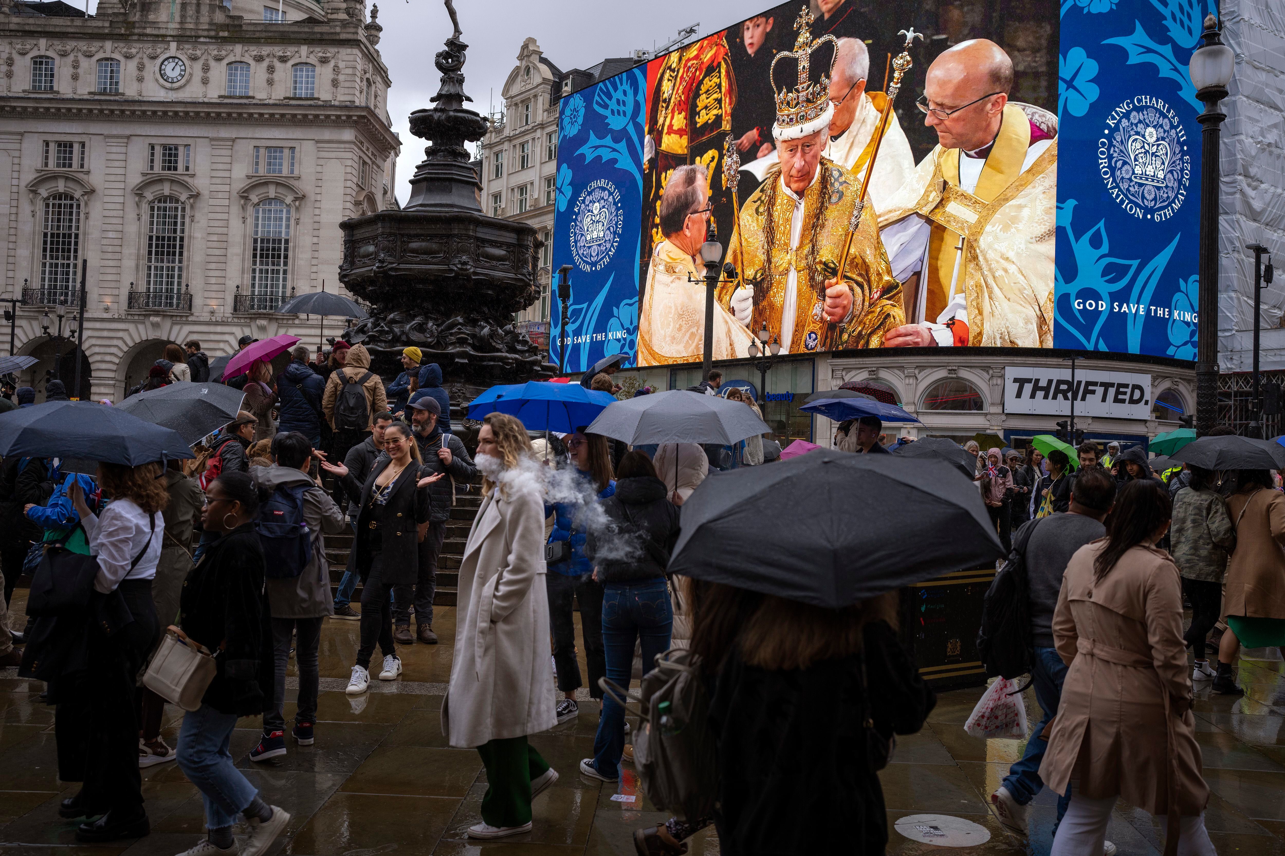 Varias personas pasaban el sábado junto a una pantalla gigante en el centro de Londres, que mostraba una imagen del rey Carlos III de Gran Bretaña durante la ceremonia de coronación en la Abadía de Westminster.
