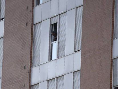El presunto asesino se asoma a la ventana del edificio en el que se ha atrincherado.