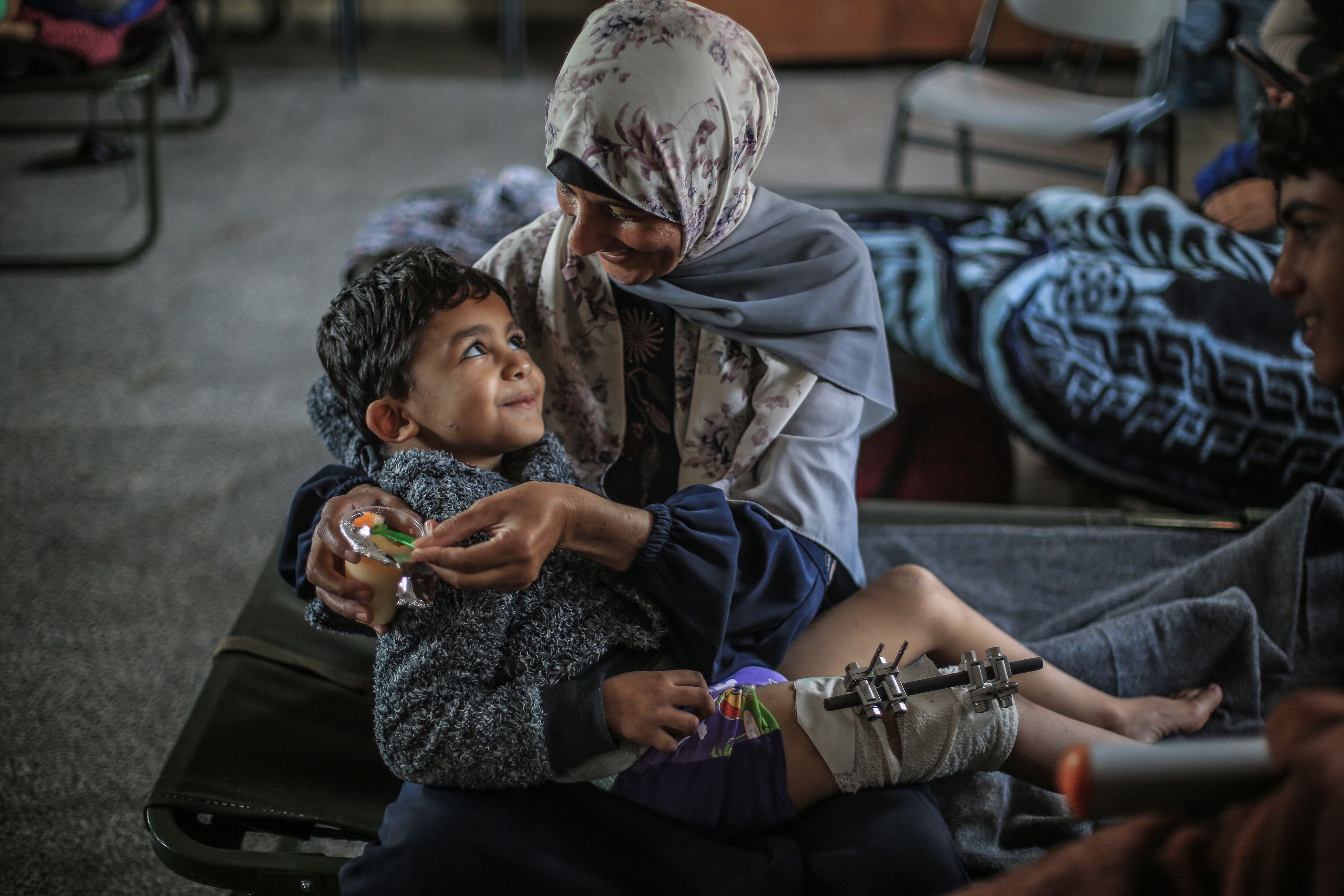 Un niño palestino herido y uno de sus familiares descansan en un refugio improvisado en un colegio en Jan Yunis, al sur de la franja de Gaza.