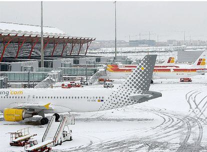 Aviones de Vueling e Iberia hoy en Barajas, aeropuerto que ha estado cerrado cinco horas por el temporal y la nieve