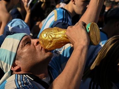Un aficionado besa una réplica de la copa del mundo al celebrar la victoria argentina frente a Croacia en Buenos Aires, el 13 de diciembre de 2022.