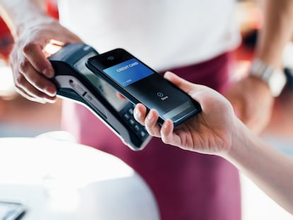 Un cliente paga con su teléfono móvil en un restaurante.