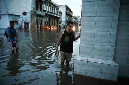 Dos personas atraviesan una de las calles inundadas por el paso del huracán 'Ian', en La Habana (Cuba), el 28 de septiembre de 2022.