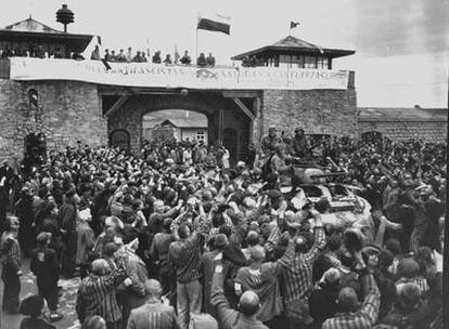 Prisioneros en Mauthausen reciben a las tropas que liberaron el campo en 1945. En la torre, una pancarta de los españoles.