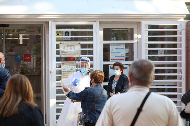 Una sanitaria sale a atender a las numerosas personas que hacen cola en el Centro de Salud Vicálvaro-Artilleros en el distrito de Vicálvaro, en Madrid el 28 de septiembre.