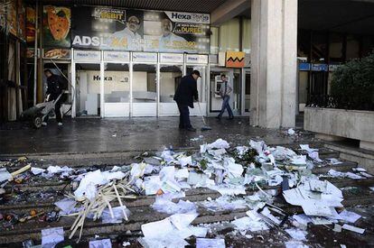 Un trabajador limpia una estación de trenes de Túnez, incendiada durante la madrugada del 15 de enero. Durante la noche se han sucedido los disturbios y los saqueos en los suburbios de la capital tunecina.
