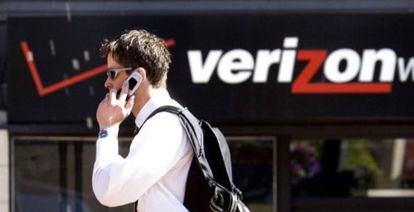 Un hombre habla por teléfono ante una tienda de Verizon.