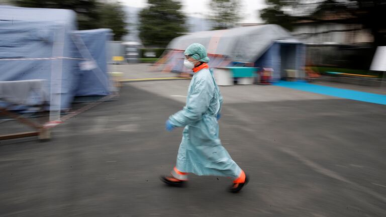 Un trabajador sanitario camina entre las instalaciones de emergencia instaladas en Brescia, al norte de Italia.