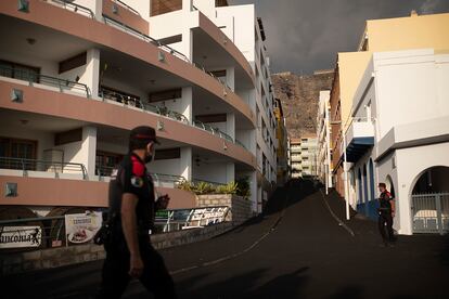 Agentes de la Policía Canaria caminan por una calle cubierta por cenizas volcánicas en Puerto de Naos (La Palma), lugar evacuado el 19 de septiembre.  