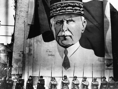 Una parada militar delante de un mural con el retrato del mariscal Pétain en Vichy durante la Segunda Guerra Mundial.