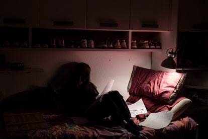 Una joven estudia en su cama para preparar el examen de Selectividad.