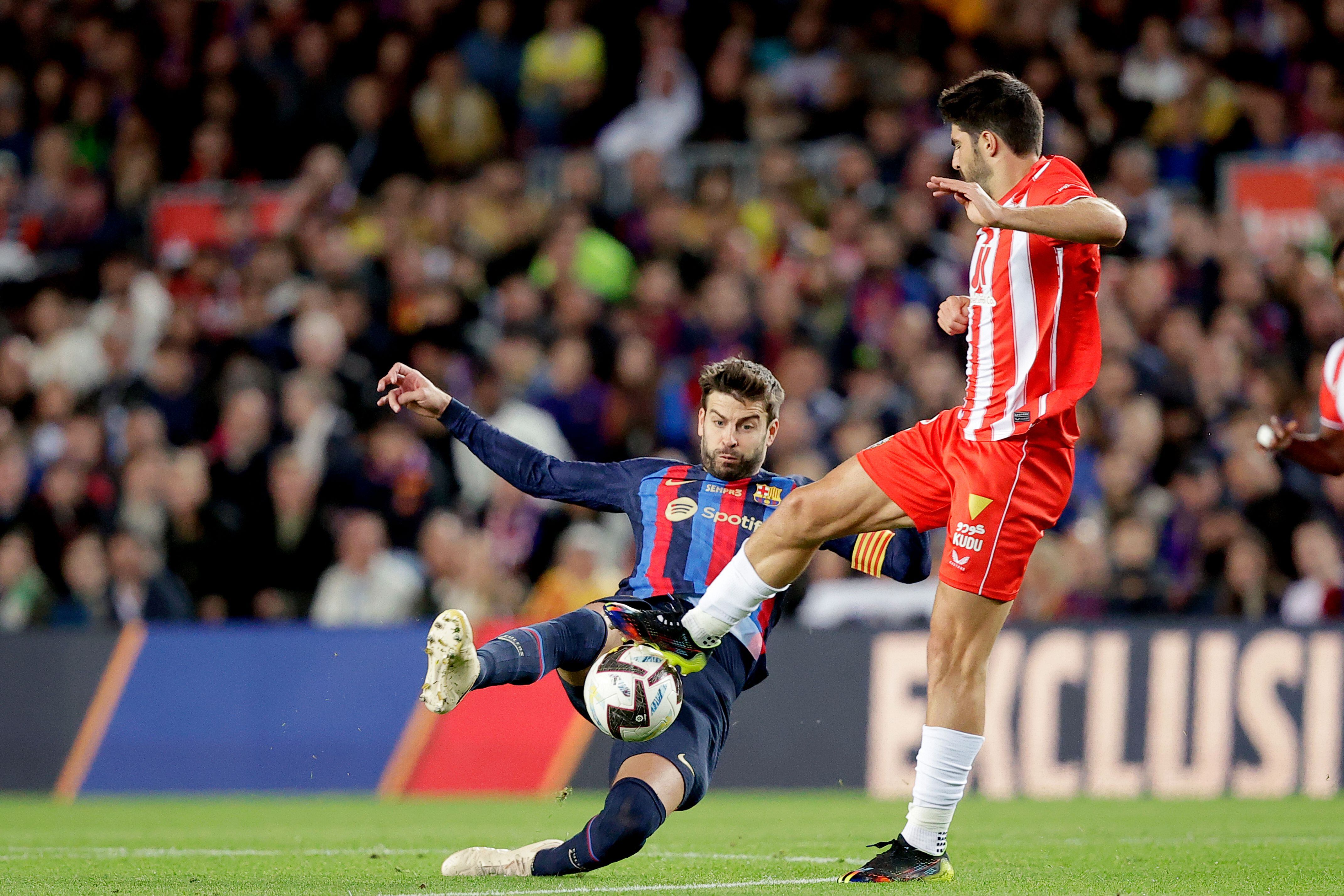 Piqué se lanza al suelo para interceptar el avance de Gonzalo Melero, del Almería, durante el partido de La Liga que sirve de despedida del jugador del Barcelona.